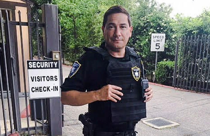 Bodyguard in bulletproof vest standing in front of gate
